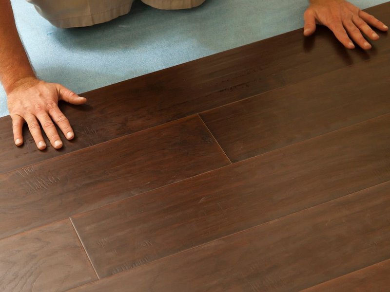 closeup of person installing flooring - Big Dog Flooring in Indianapolis, IN